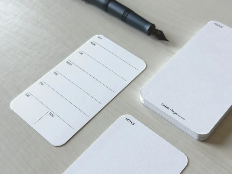 A small, business-size weekly planner card in a horizontal layout with the weeks in the front and an empty notes section in the back.